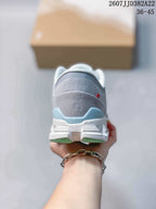 Rear view of the gray sneaker showing the On logo, padded heel collar and mint outsole accents.