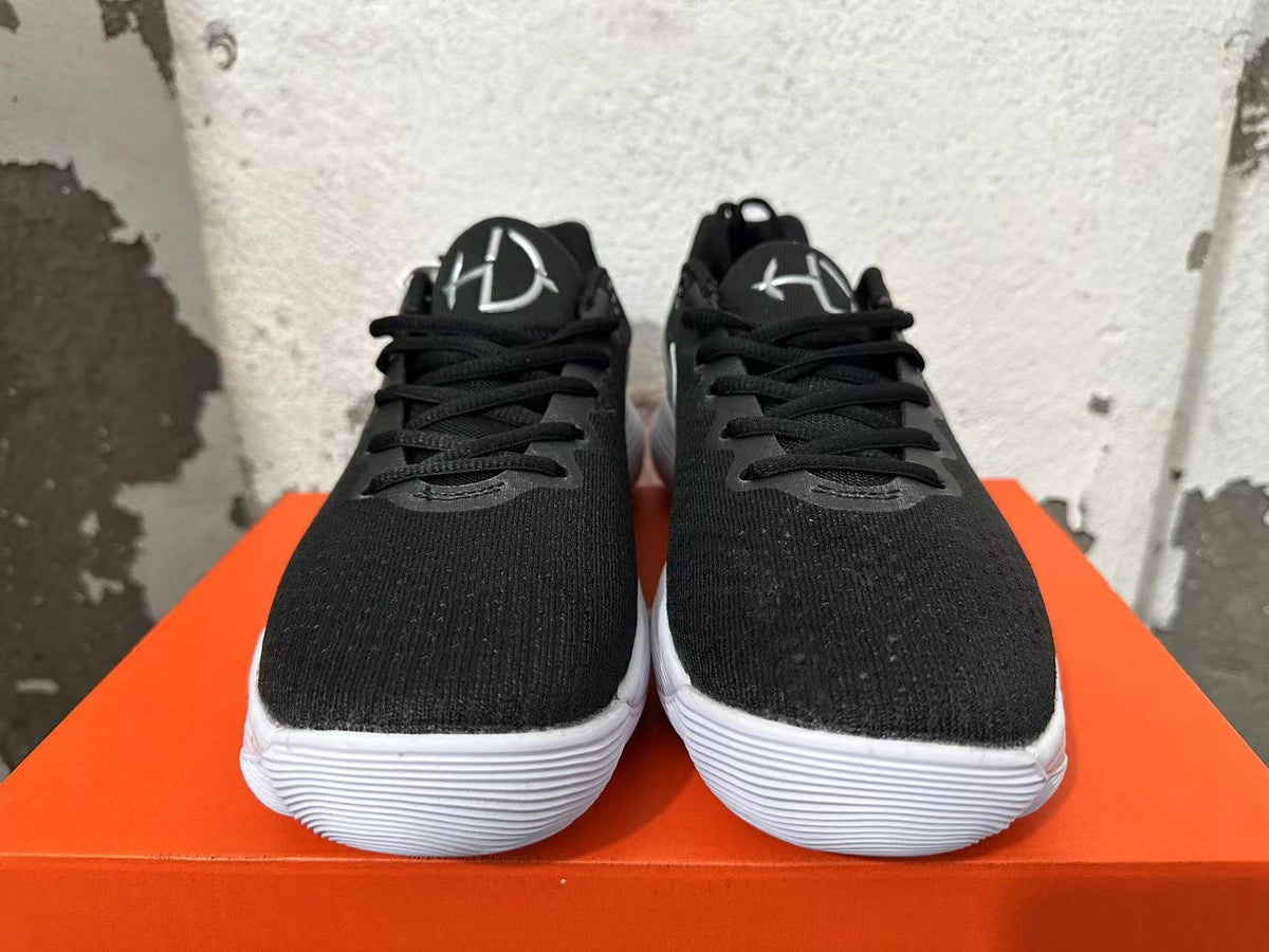 Front view of black Nike basketball shoes with lace-up closures and white outsoles