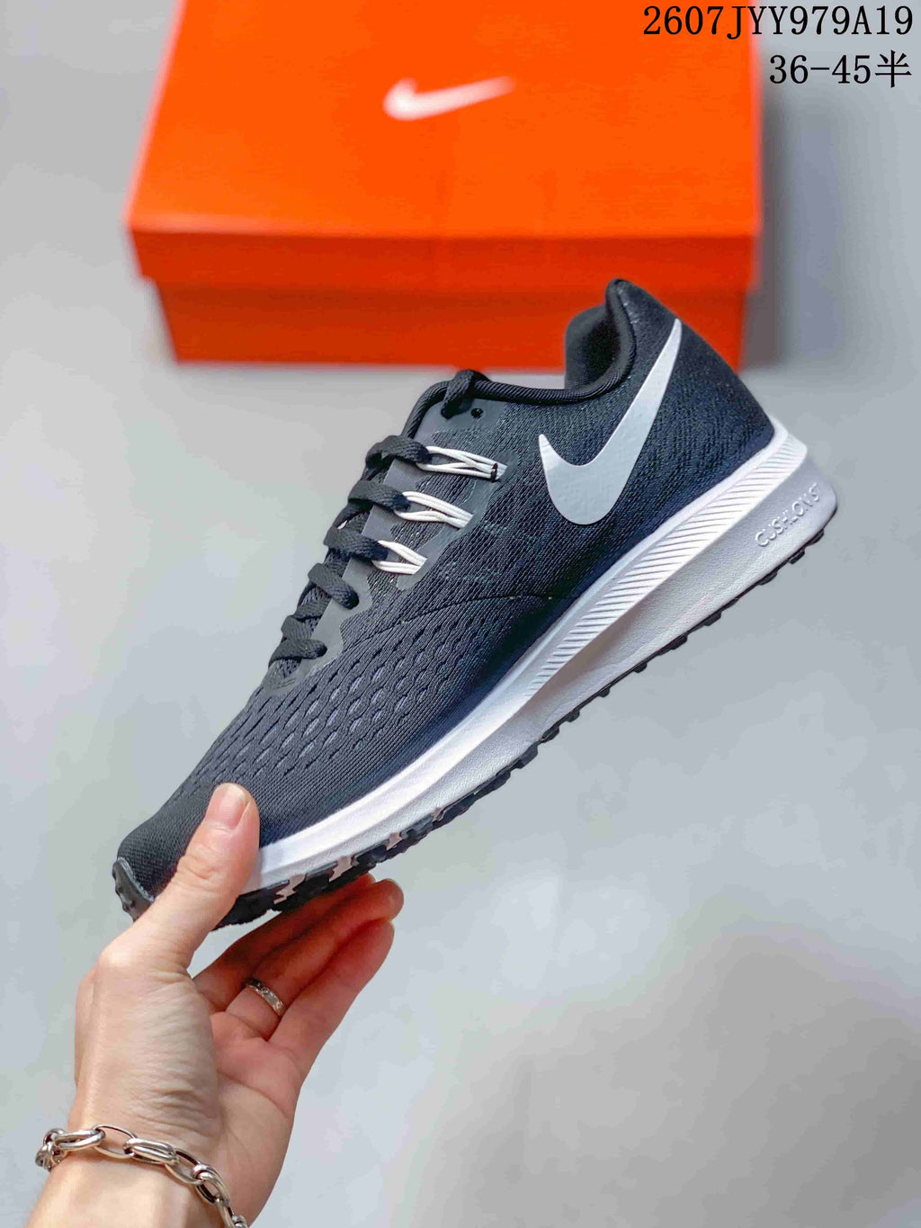 Side view showing the dark gray mesh-style upper, white Swoosh, and white midsole.