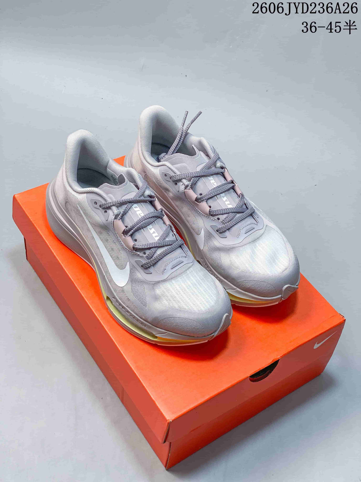 Pair of silver-gray and white Nike Pegasus Plus running shoes on an orange shoebox.