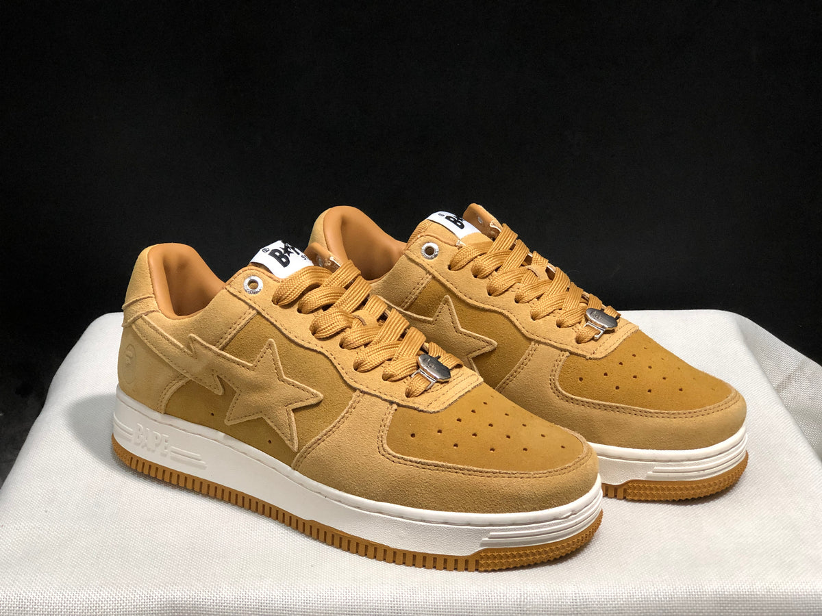 Three-quarter front view of the wheat Bape Sta pair with tonal star panels and contrasting white midsoles.