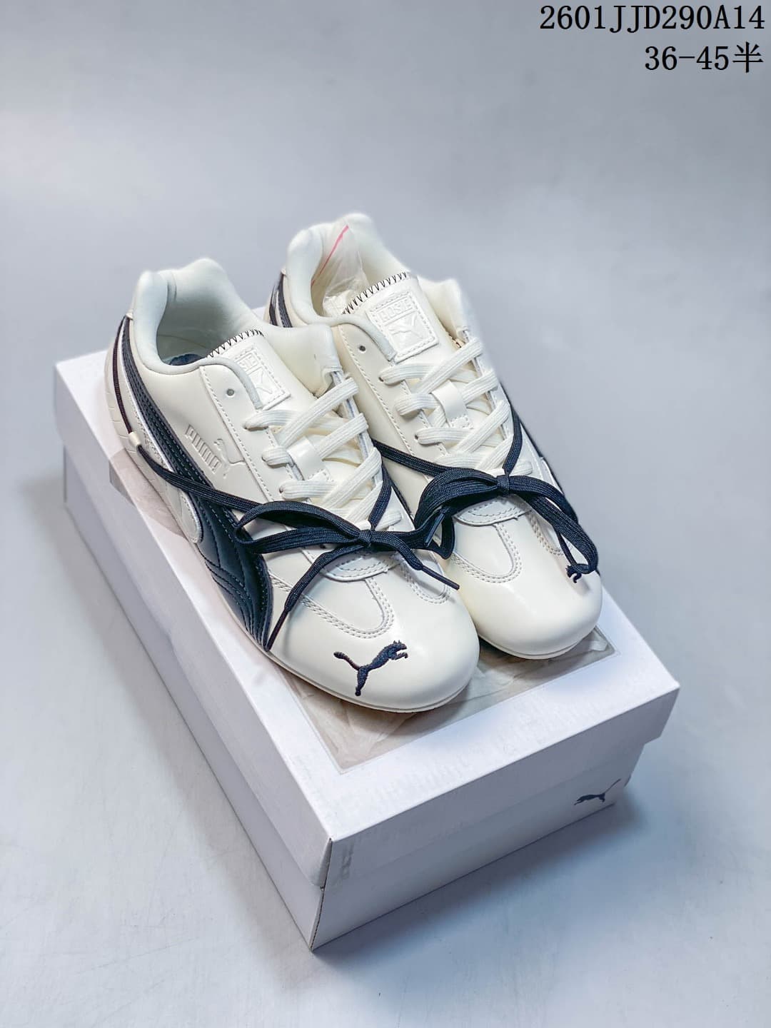 Pair of white PUMA Speedcat TTF sneakers with navy side stripes and contrasting laces.