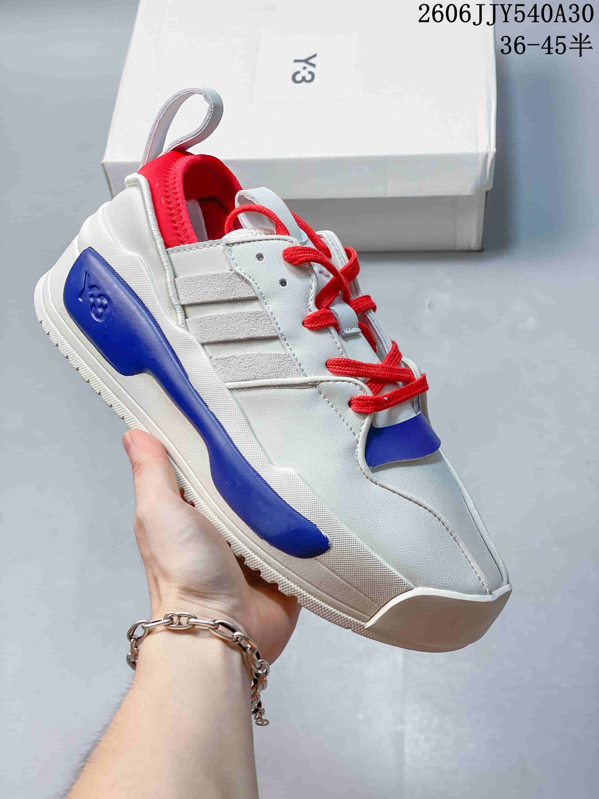 White sneaker with red laces, red lining and a blue side accent.