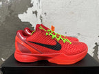 Side view of a red Nike Kobe shoe with a black Swoosh and textured upper