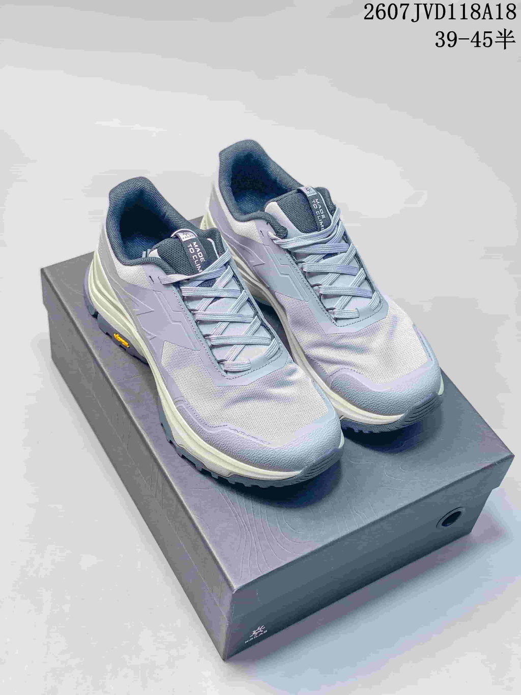 Gray KAILAS hiking sneakers displayed on a shoebox, showing the lace-up design, mesh-textured upper, and style code overlay.