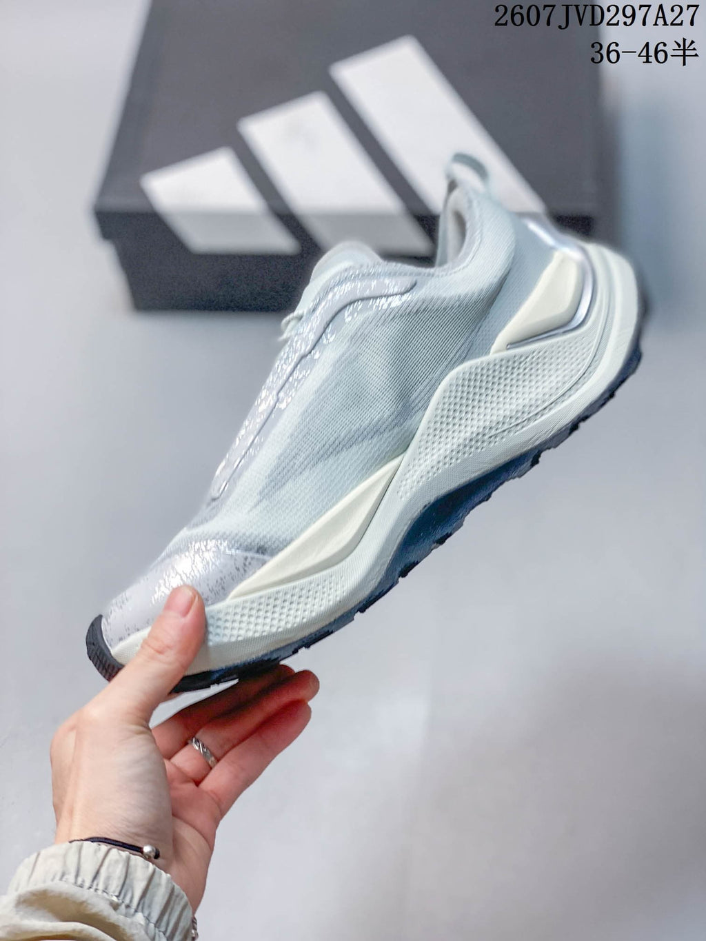 Side profile highlighting the layered light gray upper, sculpted midsole, and dark outsole.