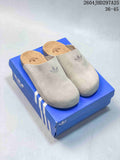 Pair of light neutral adidas Adimule closed-toe slippers on a blue shoe box.