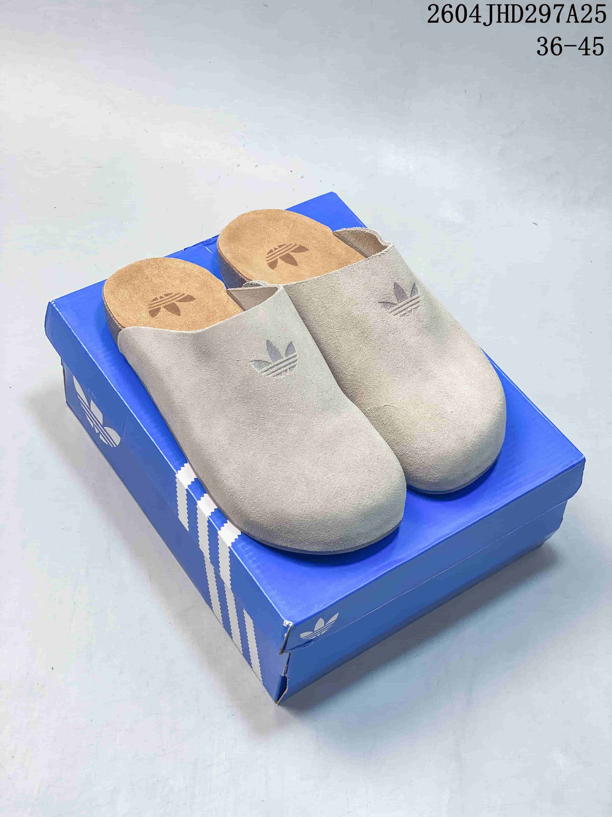 Pair of light neutral adidas Adimule closed-toe slippers on a blue shoe box.