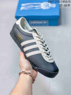 Angled side view showing the textured navy upper, white stripes and gold adidas side label.