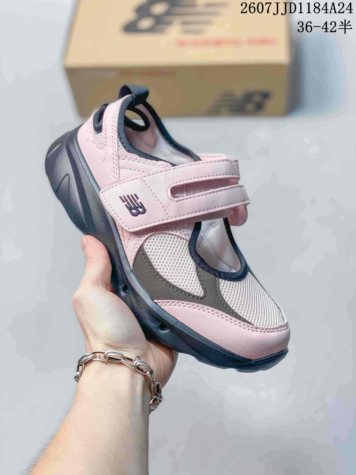 Three-quarter view of the pink and gray sneaker showing the Mary Jane-style strap and textured dark outsole.