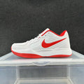White Nike low-top sneaker with a red Swoosh, red collar and outsole accents, shown from the side.