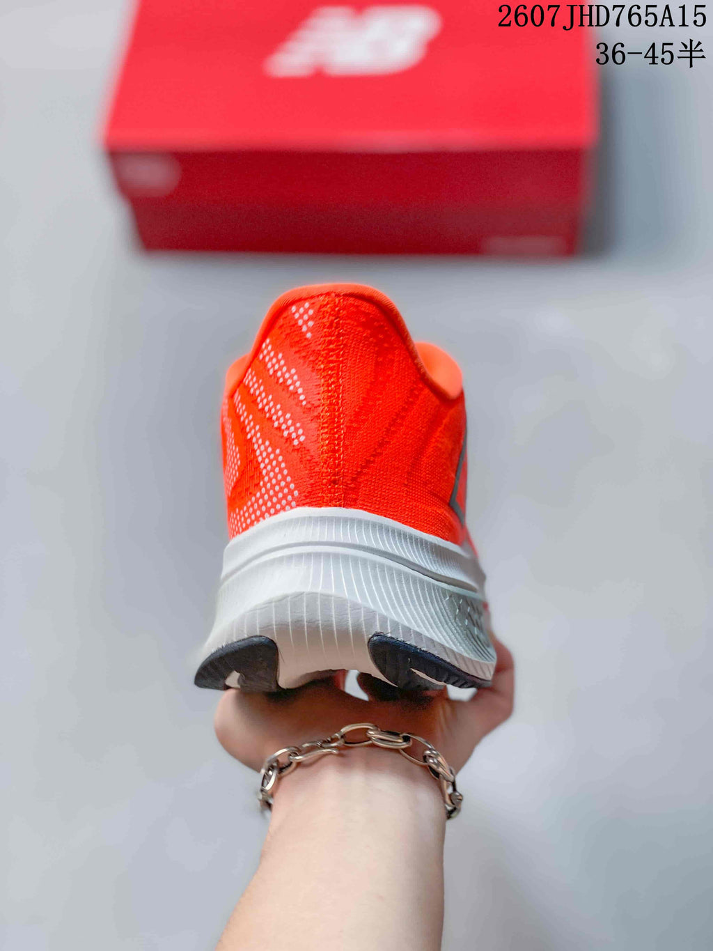 Rear view showing the orange heel, white midsole, and black outsole sections.
