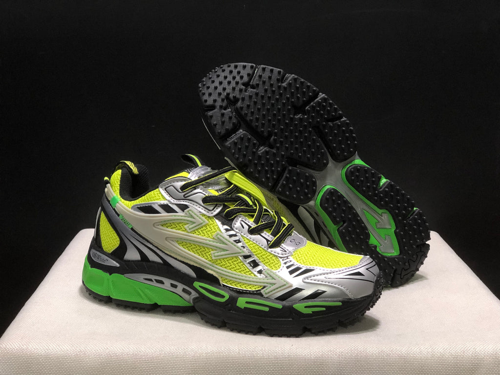 Three-quarter view with one shoe lifted to reveal the black textured outsole and green outsole accents.