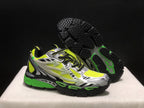Three-quarter view with one shoe lifted to reveal the black textured outsole and green outsole accents.