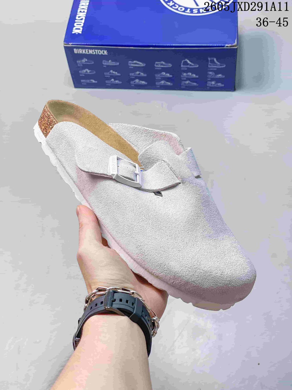 Pale gray suede-like closed-toe sandal with an adjustable buckle, shown beside a Birkenstock-branded box.