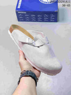 Pale gray suede-like closed-toe sandal with an adjustable buckle, shown beside a Birkenstock-branded box.
