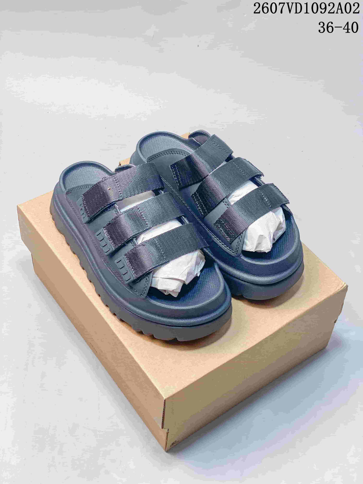 Pair of dark blue-gray platform slide sandals with three wide straps.