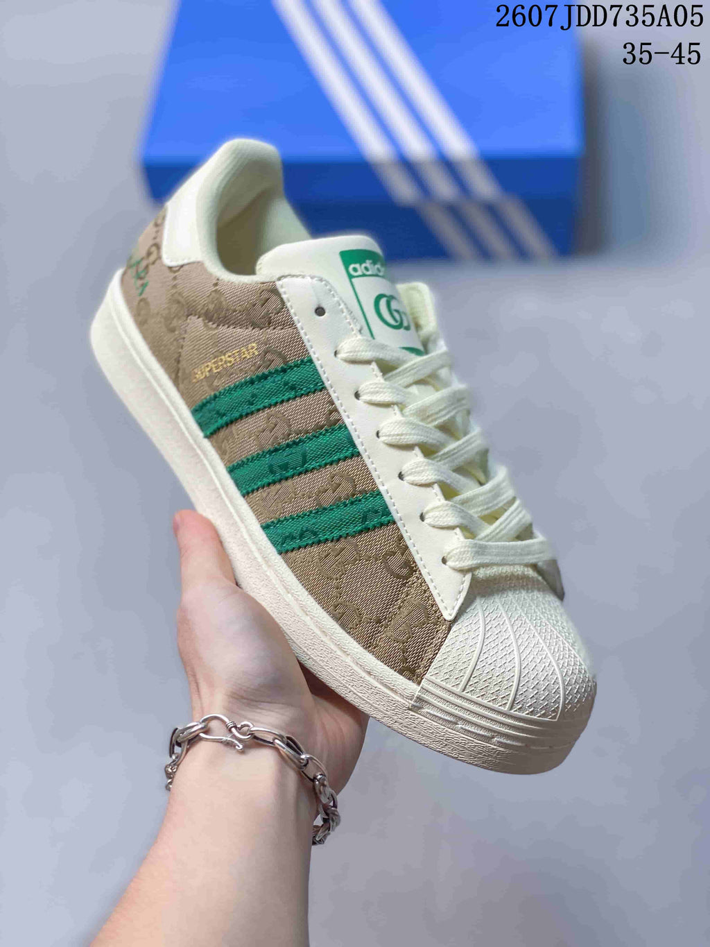 Angled side view showing the patterned beige upper, green stripes, shell toe, and off-white rubber sole.