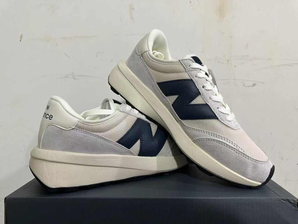 New Balance U370 sneakers displayed together, showing the side logo and layered upper.