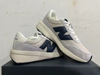New Balance U370 sneakers displayed together, showing the side logo and layered upper.