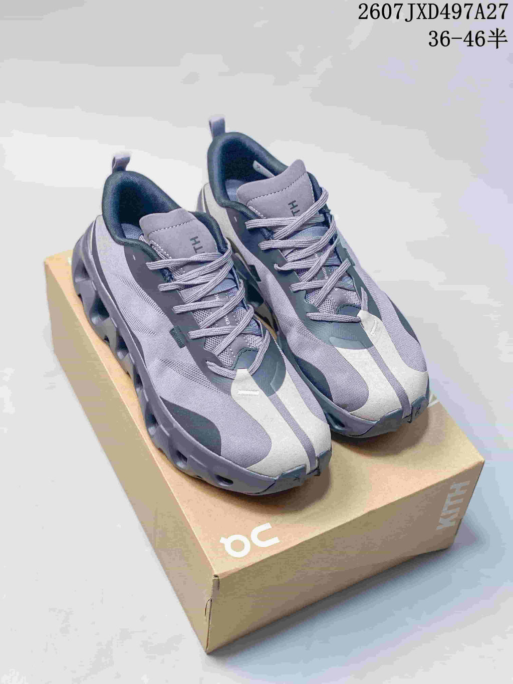 Pair of gray, black and white On sneakers displayed on a shoebox, with the style code and size range shown above.