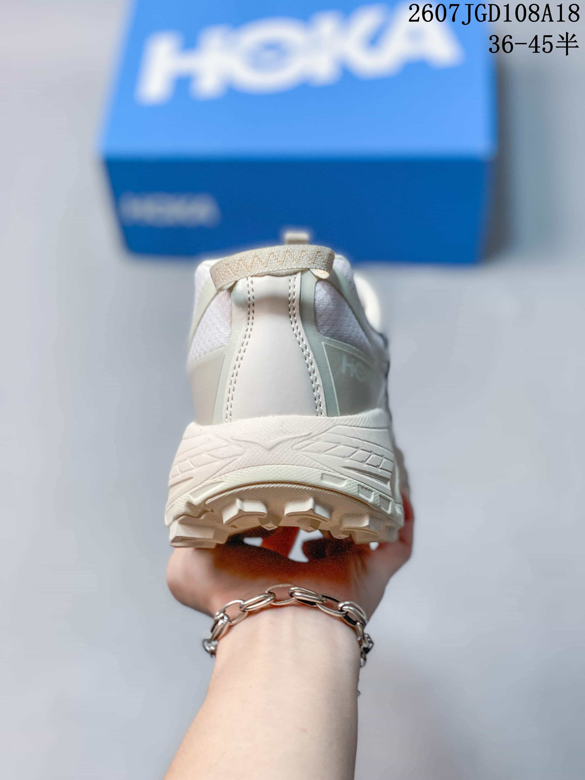 Rear view of a white and grey sneaker showing the padded heel collar, pull tab and rugged outsole.