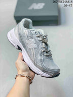 Silver and white New Balance 740 sneaker with tonal layered overlays.