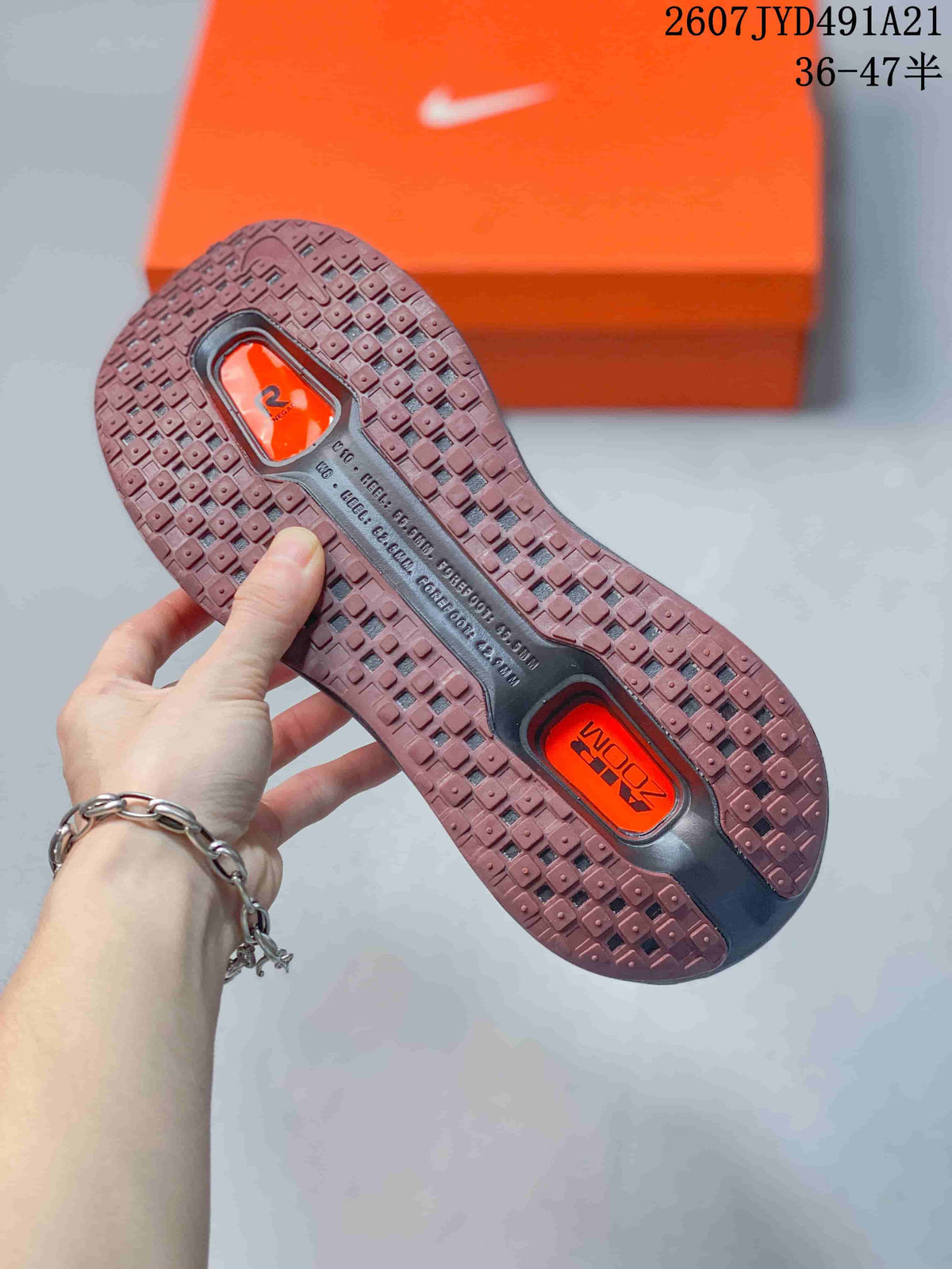 Close view of the sneaker outsole showing segmented brown rubber tread and orange cushioning windows.