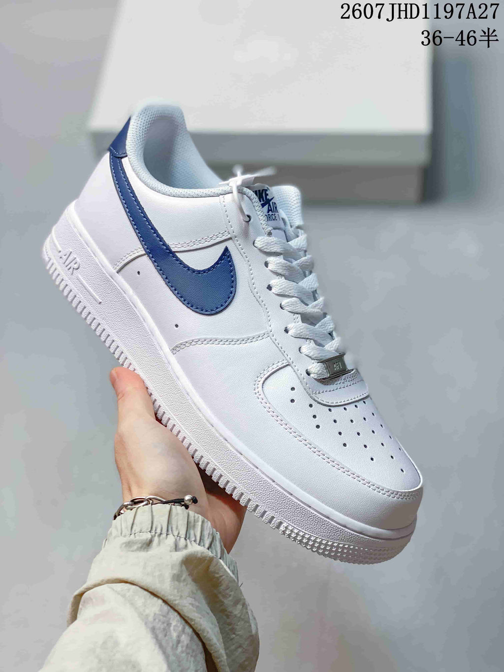 Angled side view showing the white upper, blue Swoosh, padded collar, perforated toe panel and rubber outsole.