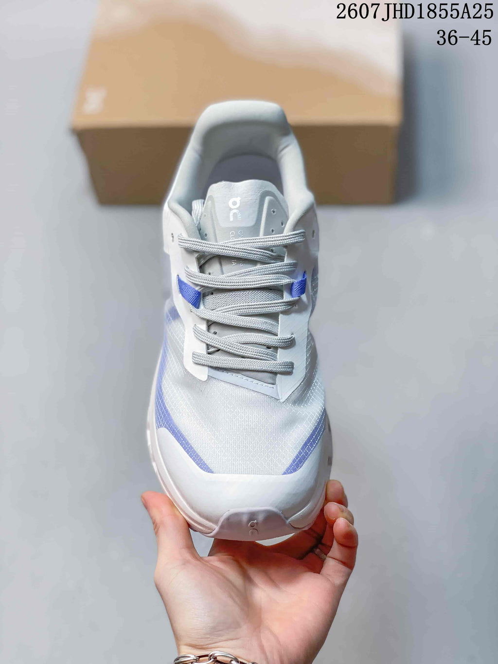 Top view of the sneaker showing the white textured upper, gray laces, blue accents, and padded tongue.
