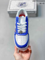 Top view showing white perforated toe box, blue overlays, white laces, and metal lace accessory.