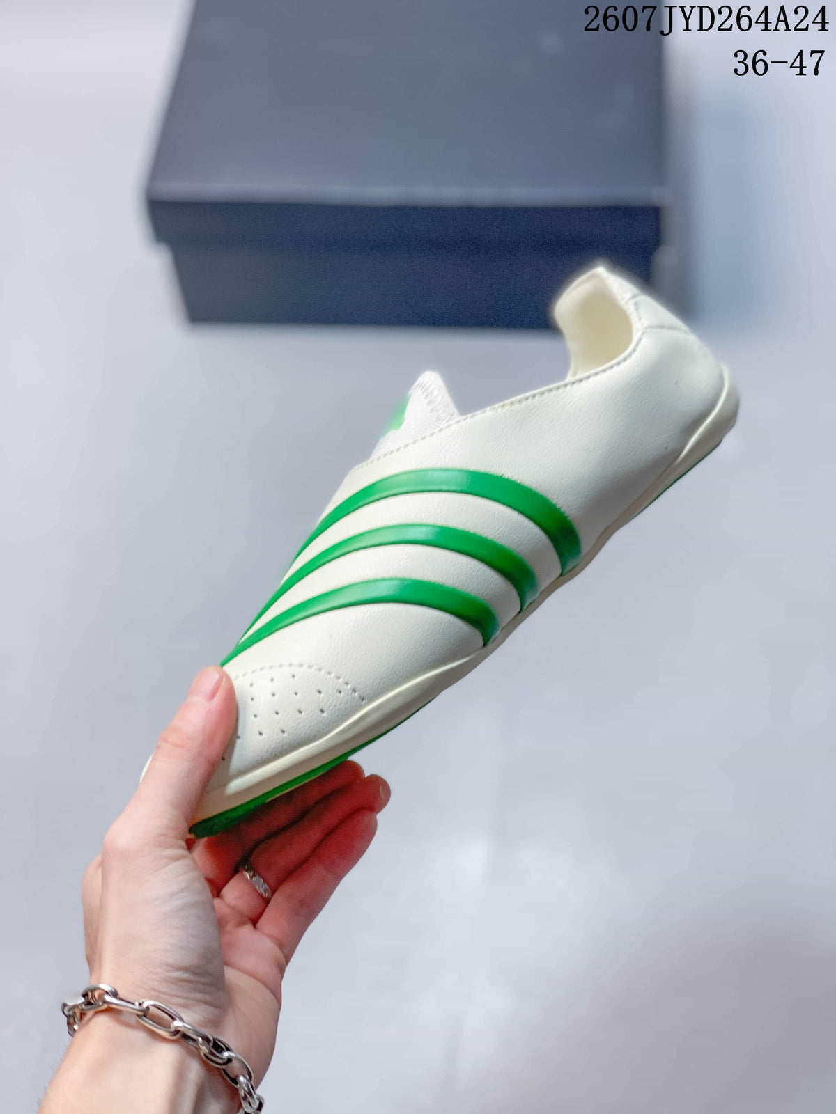 Side profile showing the off-white upper, raised green striping, perforated toe, and low outsole.