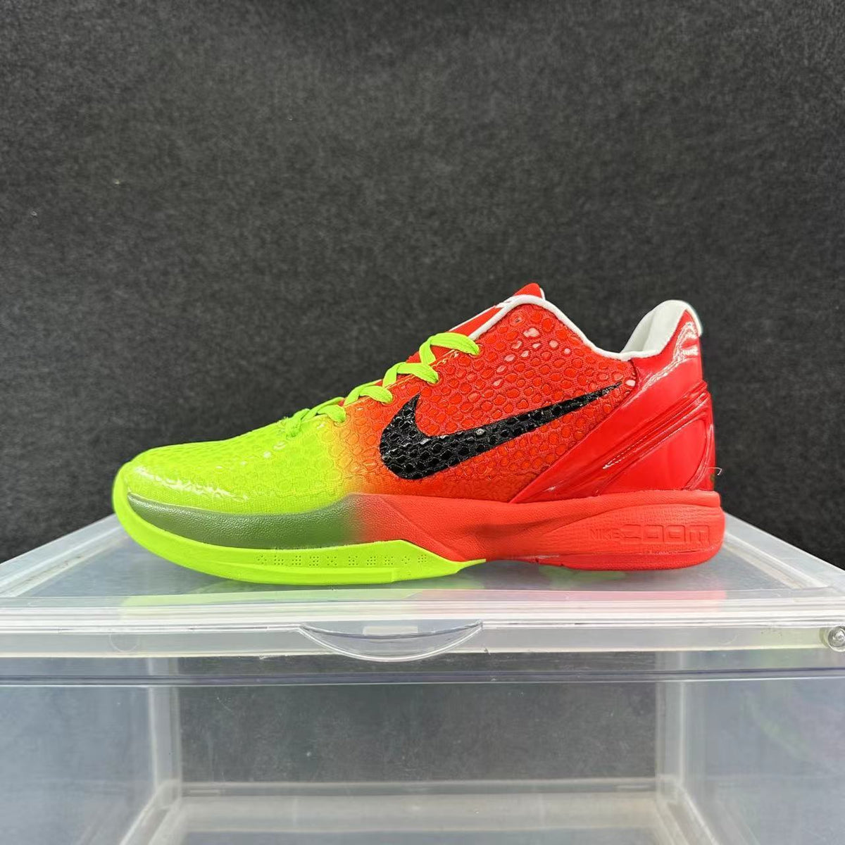 Side view of a low-top Nike basketball shoe with a neon green and red-orange color-blocked design, black Swoosh, and bright green laces.