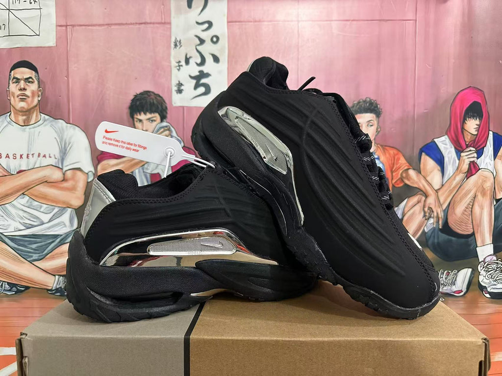 Angled view of black Nike sneakers with silver-tone accents.