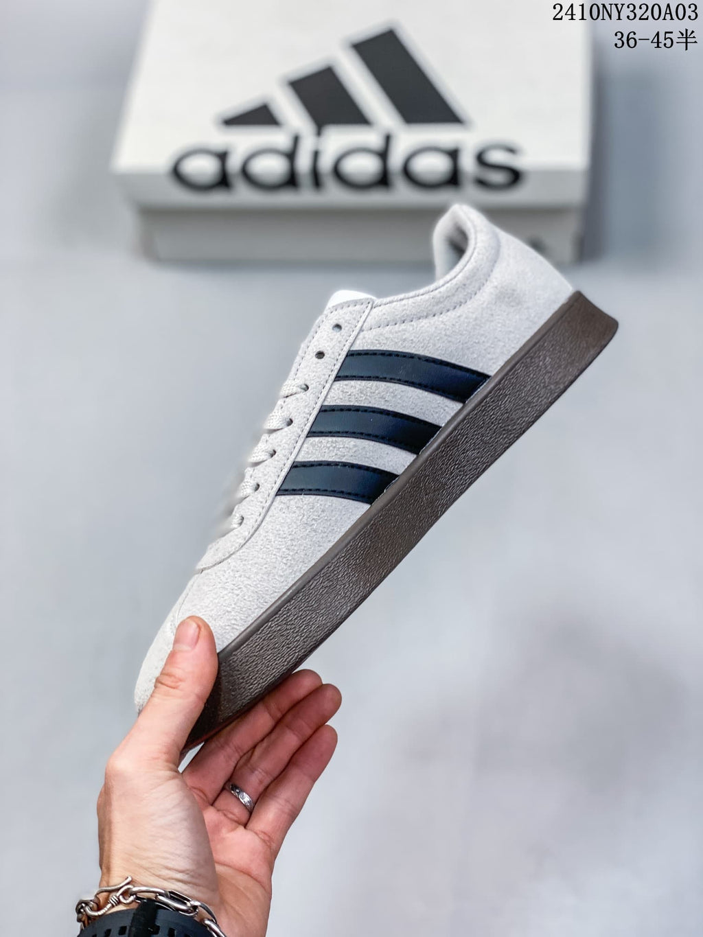 Side profile showing the white upper, black three stripes, and brown-colored outsole.