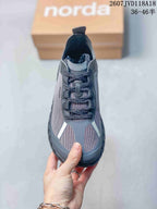 Top view of the gray sneaker showing the lace closure, patterned toe panels, and contrasting light-colored details.