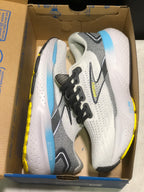 Brooks Glycerin 21 shoes shown inside an open cardboard shoe box, with white and grey uppers, black laces, blue midsole accents, and yellow outsole details.