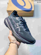 Angled side view of the dark gray ASICS sneaker showing the branded side detailing, textured upper, and layered sole.