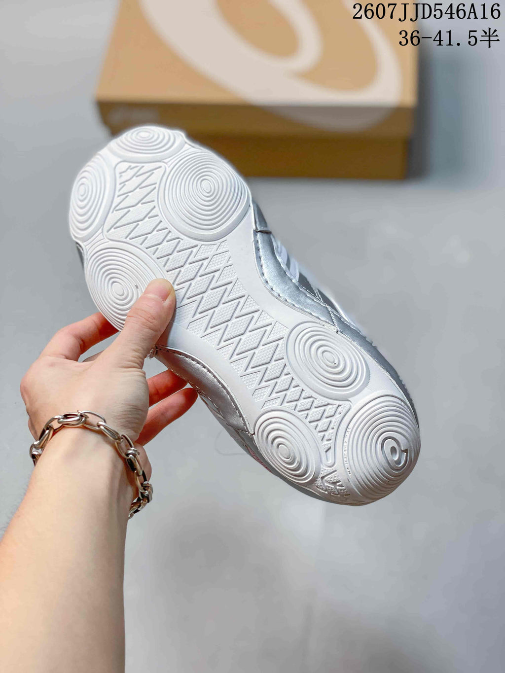 Close view of the white textured outsole with circular tread sections on an ASICS Hypersync sneaker.