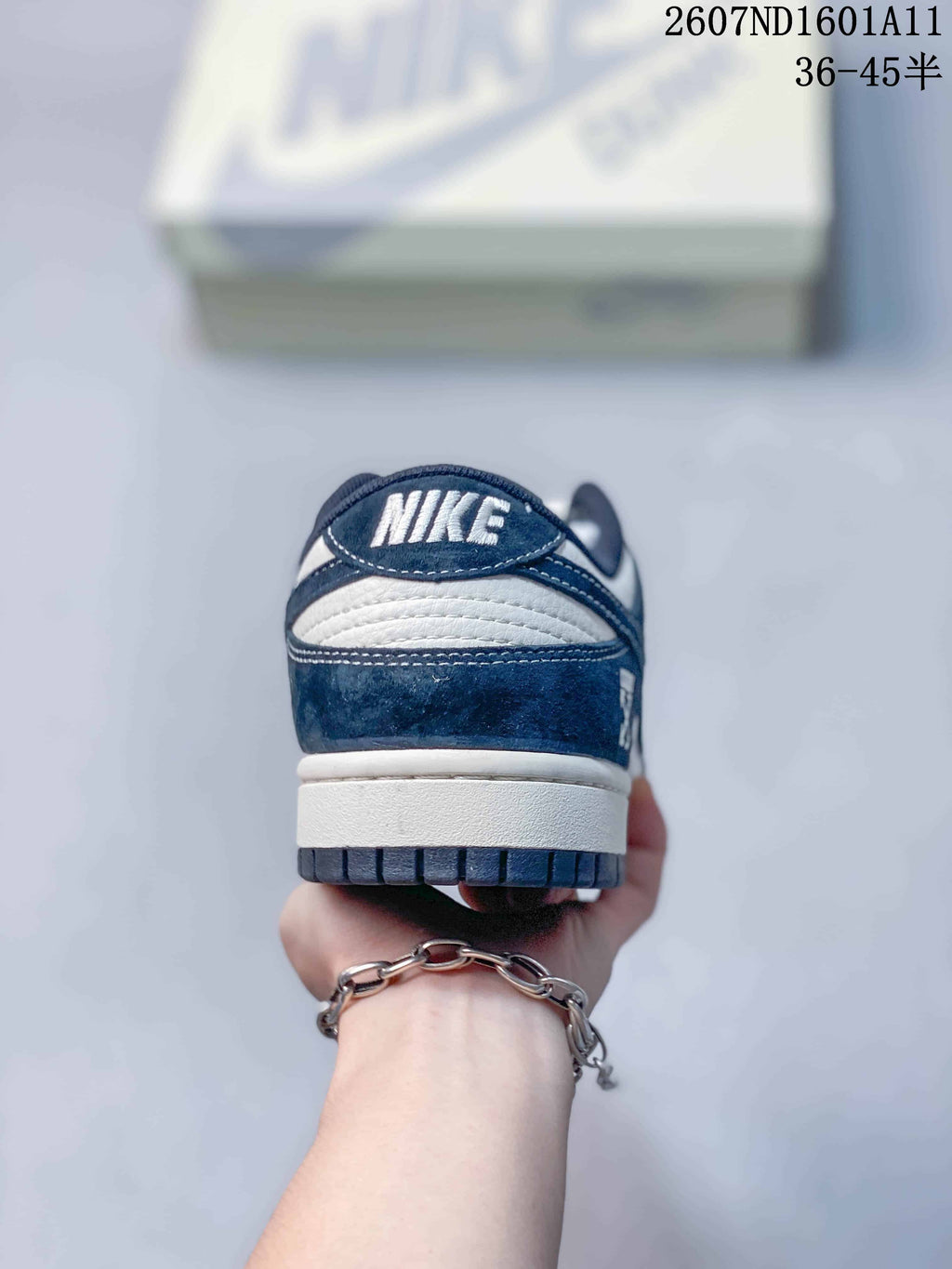 Rear view of the sneaker showing the Nike-branded heel tab, navy upper, white midsole, and dark outsole.