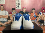 Front view of white and blue Jordan sneakers showing blue laces, Jumpman tongue logos, and textured toe panels.