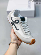 Angled view of the white low-top sneaker showing the black side detail, lace-up construction and gum outsole.