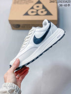 Side profile highlighting the white upper, navy Swoosh, layered panels, and lugged outsole.