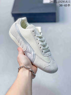 White PUMA sneaker with light blue side detailing, mesh panels, and a pale outsole.
