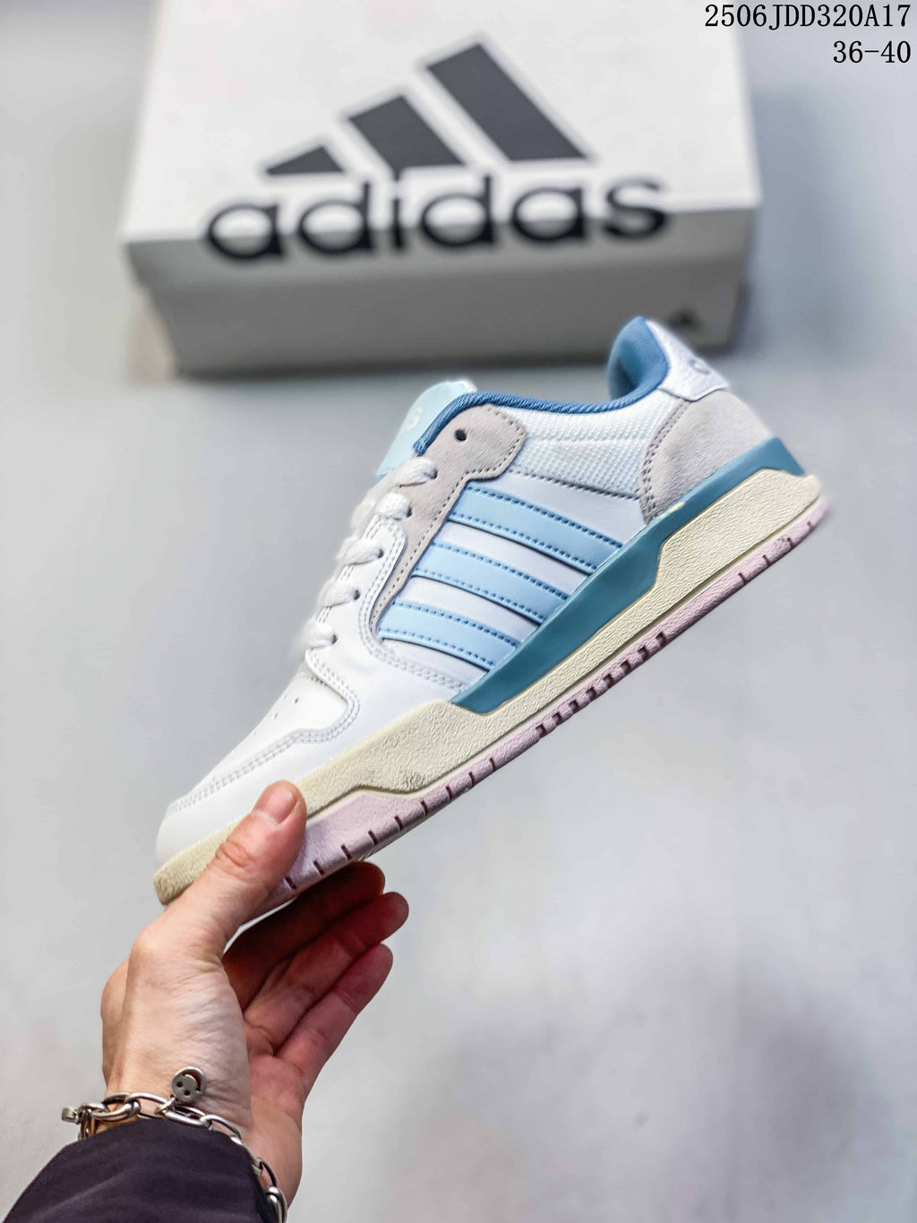 Side view of the white adidas Entrap sneaker with light blue stripes, cream midsole accents and pink outsole.
