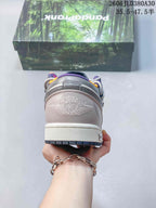 Rear view of a pink and gray low-top sneaker with embroidered wing-style branding.