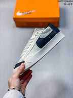 Side profile of the sneaker showing the oversized black Swoosh, white upper with embossed detailing, and white rubber midsole.