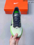Top view of one sneaker showing the pale green and white toe box, black laces, and black tongue.