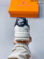 Rear view of the sneaker showing the dark padded collar, white heel panel, and printed heel graphics.