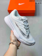 Angled side view showing the white mesh-like upper, black Swoosh and layered midsole.
